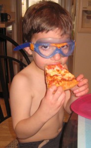 Miles eating pizza with goggles on