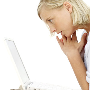 Young Woman Sitting Looking at Laptop Screen